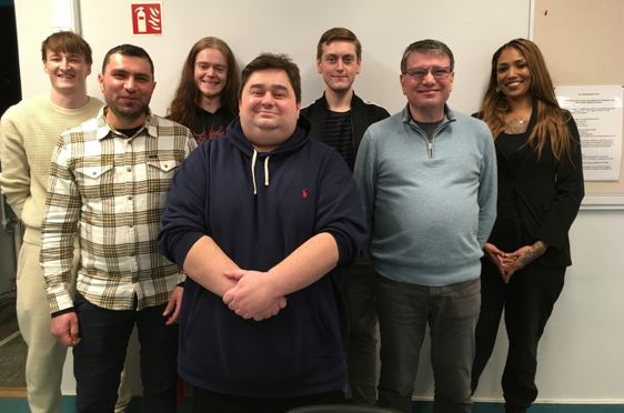 en gruppe mennesker som poserer for et bilde