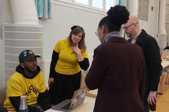 en gruppe mennesker som står rundt et bord