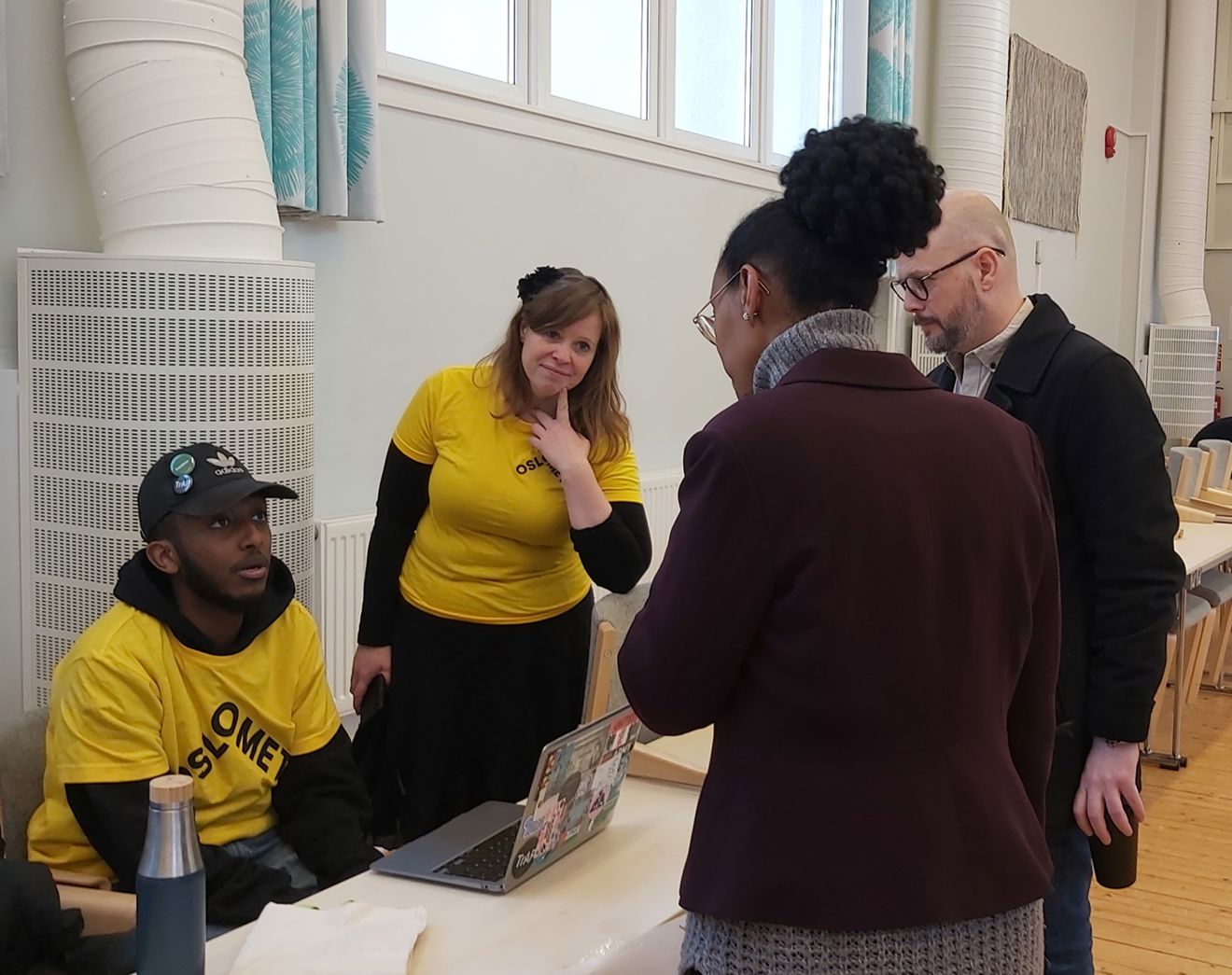 en gruppe mennesker som står rundt et bord en gruppe mennesker som står rundt et bord