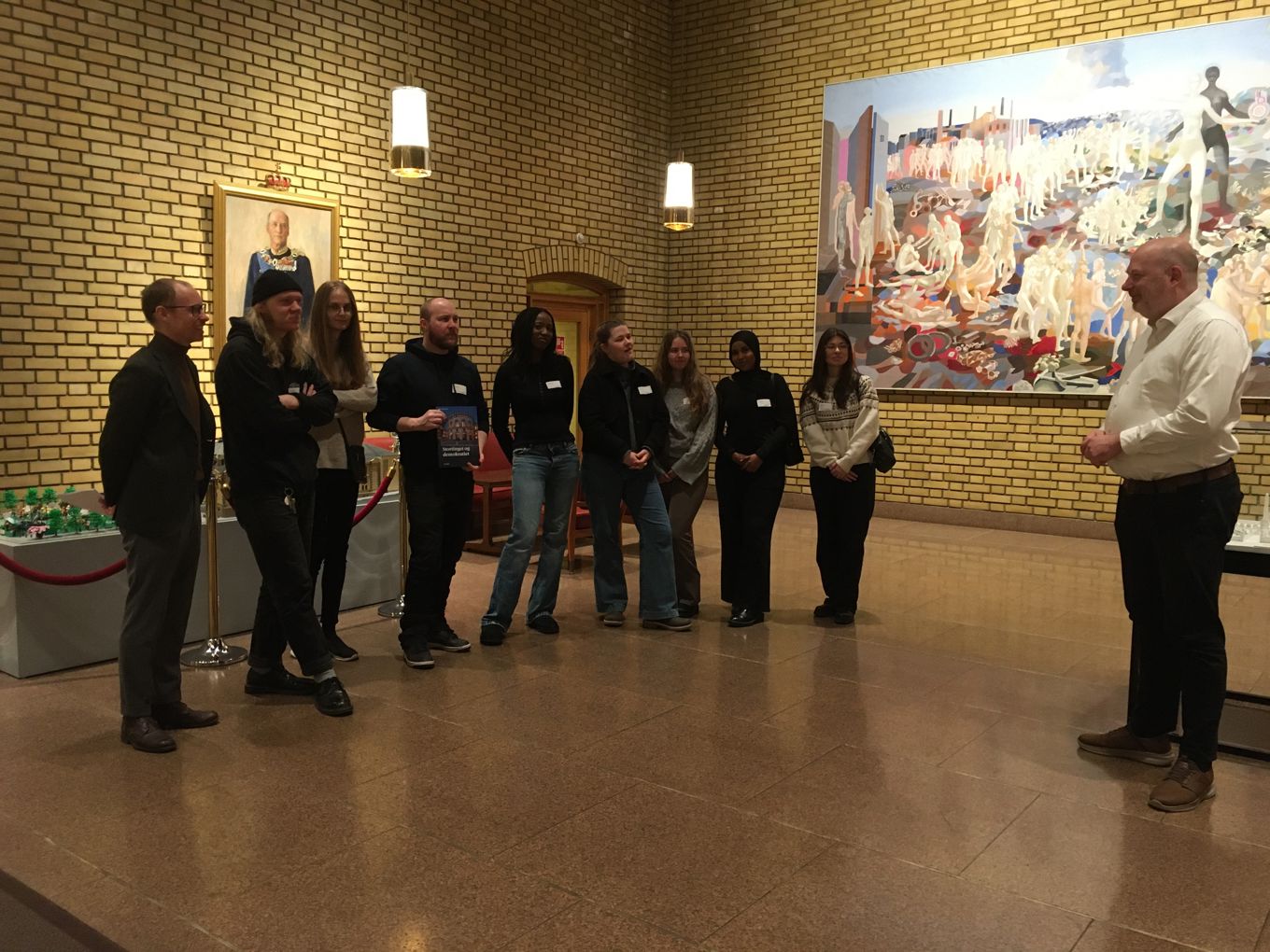 en gruppe mennesker som står i et rom en gruppe mennesker som står i et rom