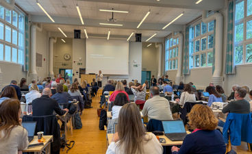 En gruppe mennesker som sitter i et rom med bærbare datamaskiner