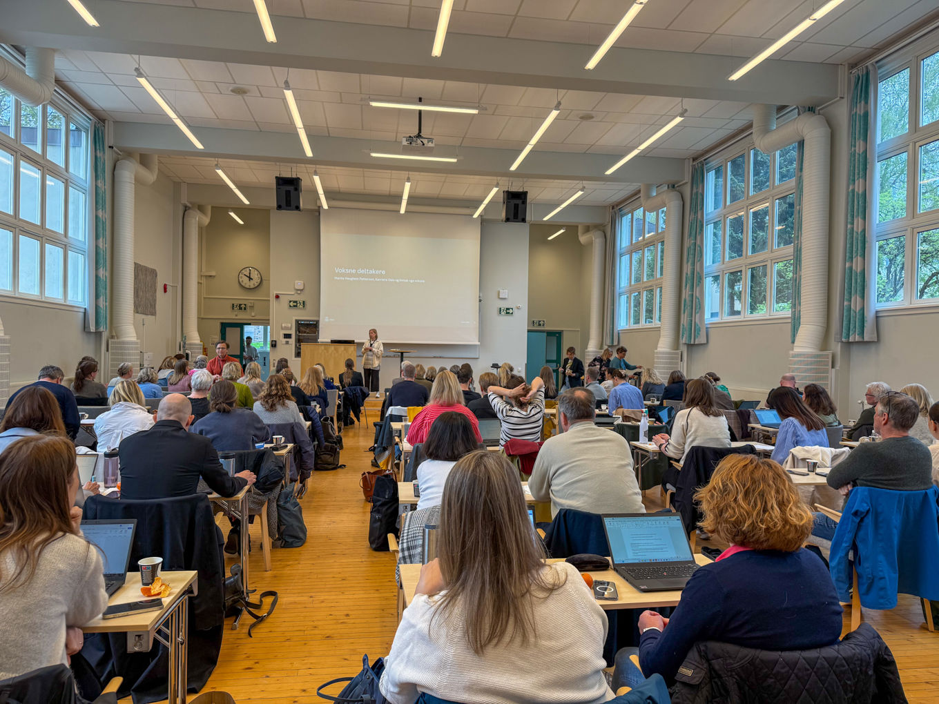 En gruppe mennesker som sitter i et rom med bærbare datamaskiner