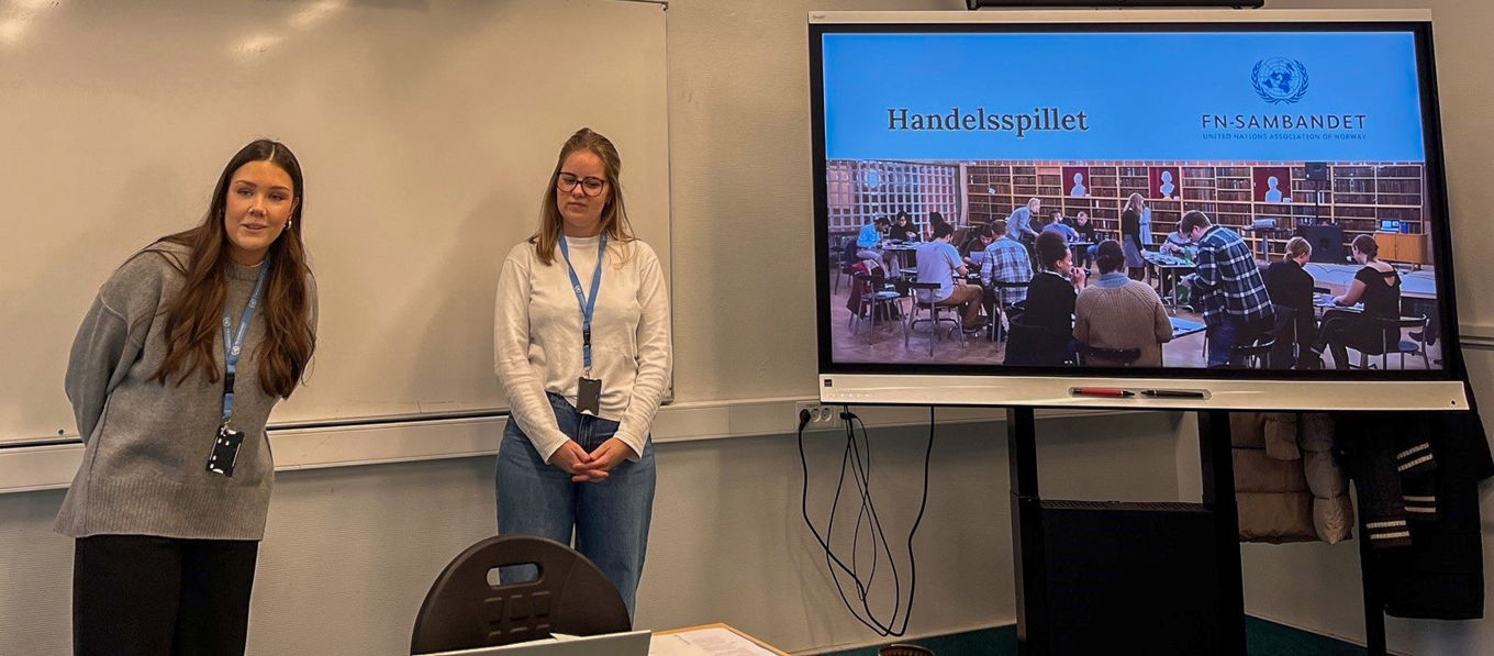 et par personr som står foran en skjerm