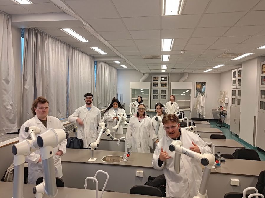 en gruppe mennesker i hvite laboratoriefrakker i et rom