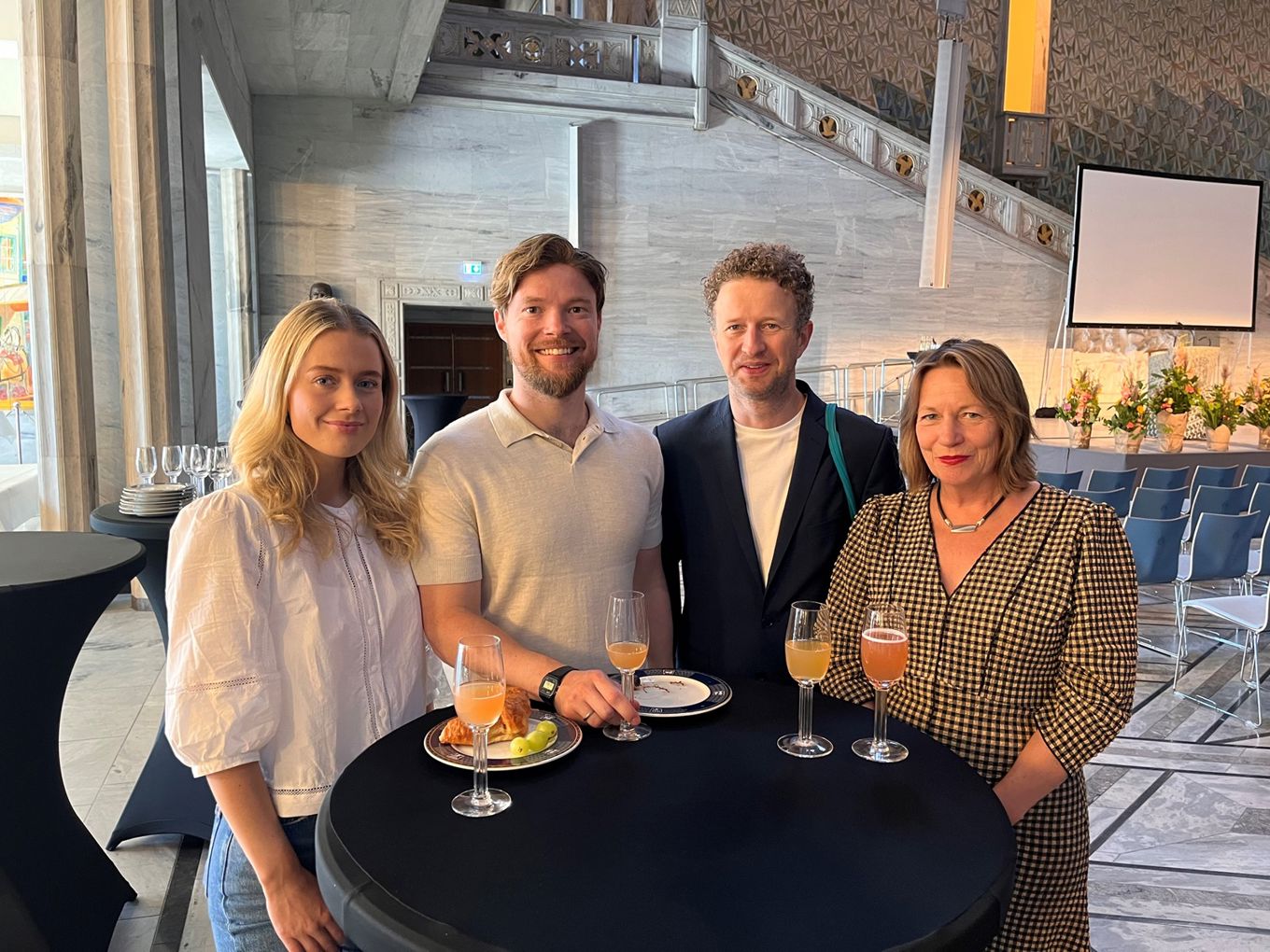 en gruppe mennesker som sitter ved et bord med mat og drikke