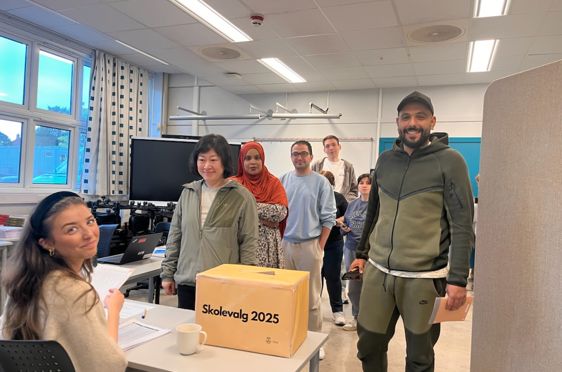 en gruppe mennesker som står i et rom